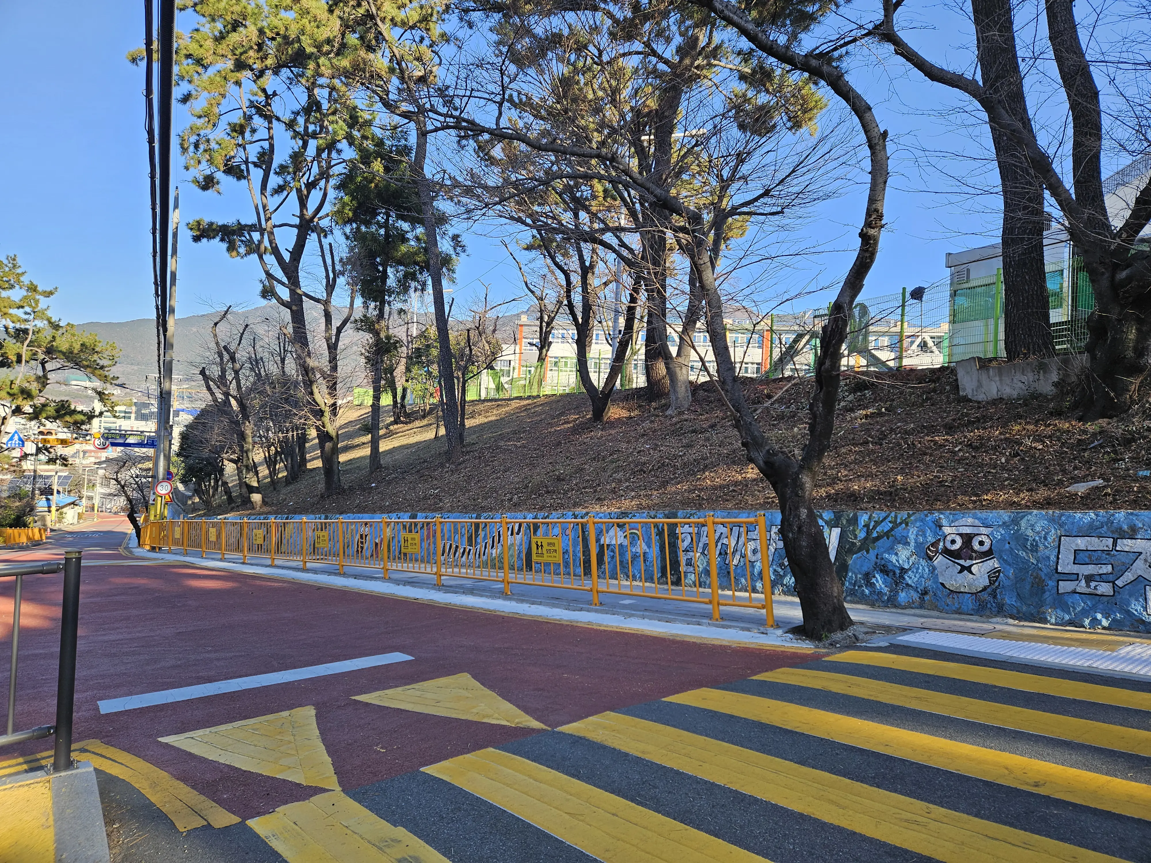 언덕 정상에서 발견한 초등학교와, 그 옆으로 보이는 까마득한 내리막길