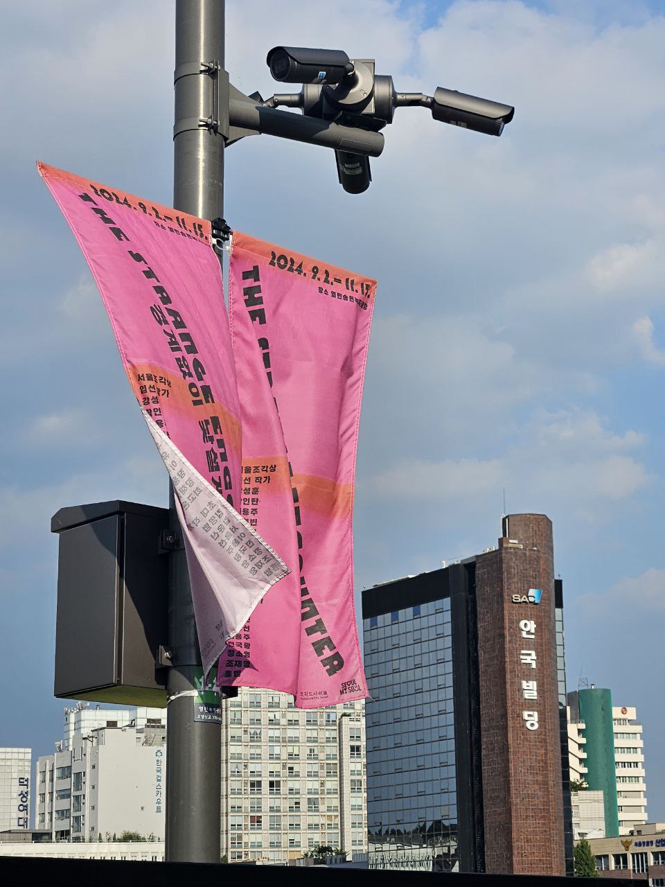 송현녹지광장 전봇대에 세로로 매달려있는 배너, 그리고 뒤에 보이는 안국제약 건물